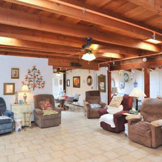 A cozy and spacious living room featuring comfortable recliners and wooden beams.