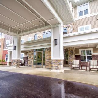 Covered entrance of a residential building with outdoor seating.