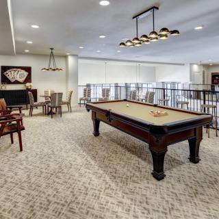 A modern game room featuring a pool table, comfortable seating, and stylish lighting.