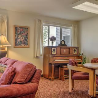 Cozy living room with a piano and comfortable seating arrangement.