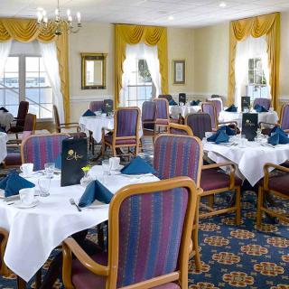 An elegant dining room with neatly arranged tables and chairs, set for a meal.