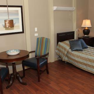 A well-furnished room featuring a bed, a dining table with chairs, and decorative elements.
