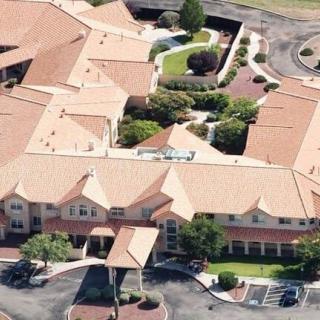 Aerial view of a large residential building complex with multiple rooftops and landscaped areas.