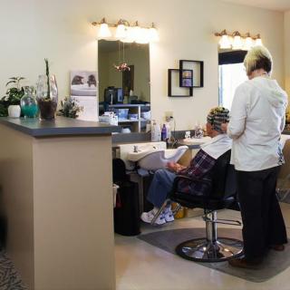 A hairdresser styling a client's hair in a salon setting.