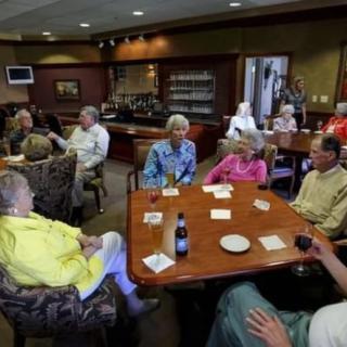 A group of seniors socializing in a dining room setting.