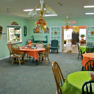 A cozy dining room with colorful table settings and decorative elements.