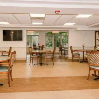 A spacious dining room with elegant furniture and large windows.