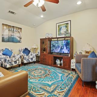 A cozy living room with comfortable seating, a television, and colorful decor.