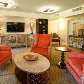 A cozy living room with vibrant orange chairs and a modern decor scheme.