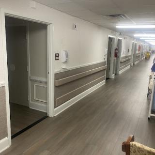 A view of a well-lit interior hallway with multiple doors and a clean floor.