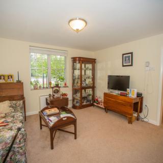 A cozy living room featuring a sofa, a wooden cabinet, and a television stand.