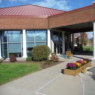 A modern building with a welcoming entrance and landscaped flower beds.