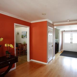 A welcoming home entrance with a red accent wall and wood flooring.