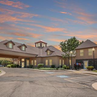 A picturesque hotel exterior captured during sunset, showcasing its welcoming architecture and landscaped surroundings.