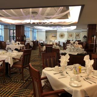 An elegant restaurant dining area with neatly arranged tables and chairs, set for guests.
