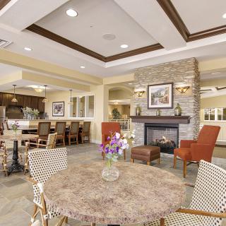 A cozy living and dining area with modern decor, featuring a fireplace and comfortable seating.