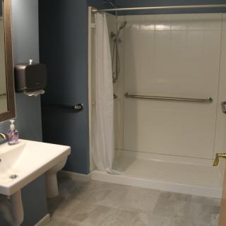 An accessible bathroom with a walk-in shower and supportive grab bars.