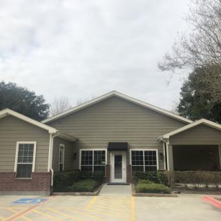 A front view of a house with a central entrance and multiple windows.