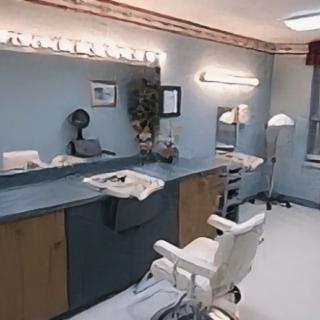 A well-lit barbershop interior with mirrors and styling chairs.