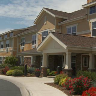 A residential building with well-maintained landscaping and colorful flowers.