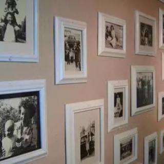 A collection of framed black and white photos displayed on a wall, showcasing vintage moments.