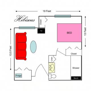 A floor plan depicting the layout of a room with a bed, sofa, table, and bathroom facilities.