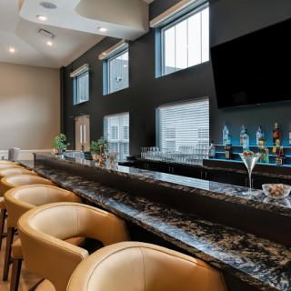 A sleek and modern bar interior featuring comfortable seating and a well-stocked countertop.