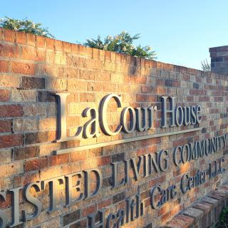 A brick wall sign for LaCour House Assisted Living Community.