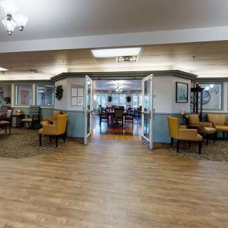 A spacious and well-lit lobby area with comfortable seating and wooden flooring.