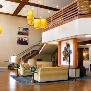 A modern hotel lobby featuring stylish furniture, decorative lighting, and contemporary artwork.