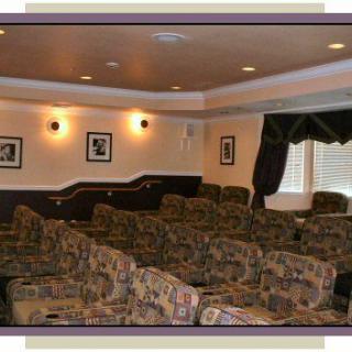 A cozy home theater with patterned seating and warm lighting.