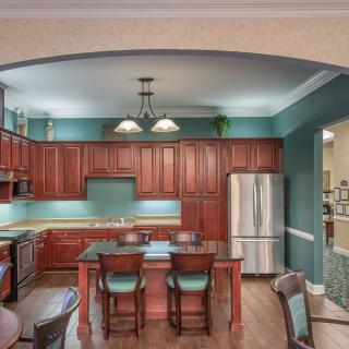 A modern kitchen with wooden cabinets and a central dining area.