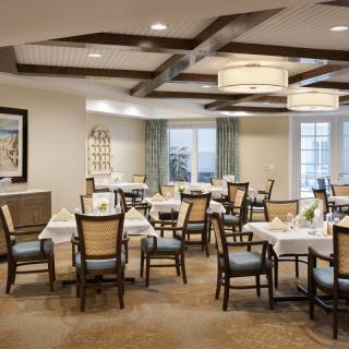 An elegant dining area with neatly arranged tables and chairs, decorated with tasteful lighting and decor.