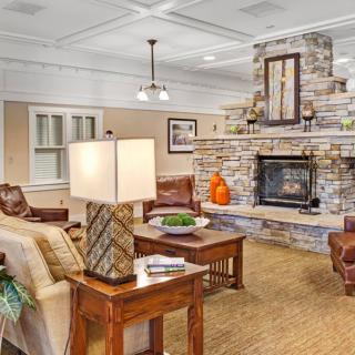 A cozy living room with a stone fireplace and comfortable seating.