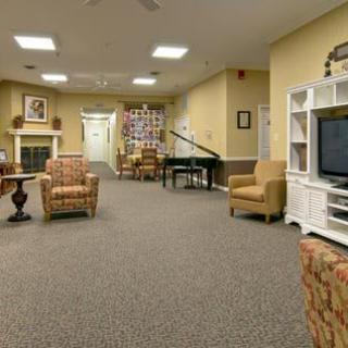 A cozy living room with comfortable seating, a television, and a piano.