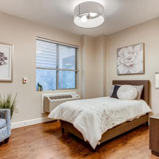 A modern, minimalist bedroom with a single bed and elegant decor.