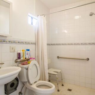 A clean and modestly decorated bathroom with a shower, toilet, and sink.