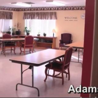 A quiet, well-lit room with tables and chairs arranged neatly.