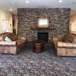 Cozy living room with two leather couches facing a stone fireplace.