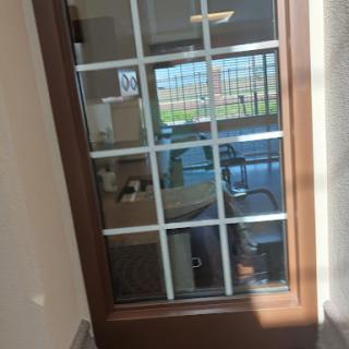 A view through a glass-paneled door into an office space.