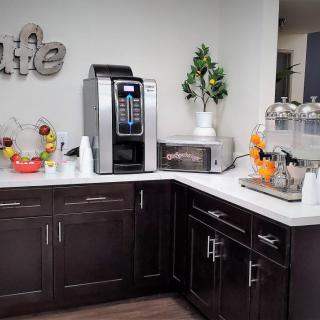 A modern kitchen corner with a coffee maker, microwave, and various decorative items on the countertop.