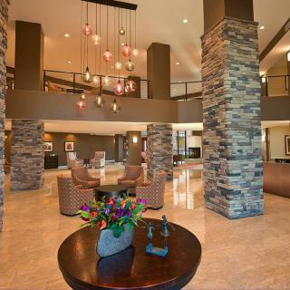 A modern lobby with elegant lighting, stone columns, and comfortable seating.
