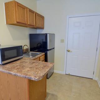 A compact kitchen area with essential appliances and cabinetry.