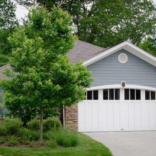 A suburban house with a well-maintained driveway and lush landscaping.