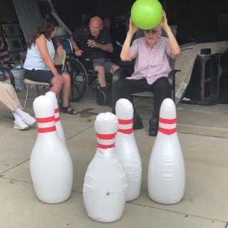 A group of people enjoying an outdoor inflatable bowling game.