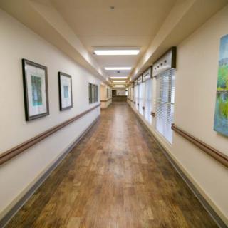 A long, well-lit hallway with framed artwork on the walls.