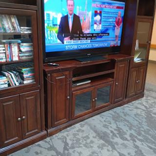A wooden entertainment center featuring a television and storage cabinets.