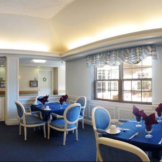 A stylish dining area with blue chairs and elegantly set tables.