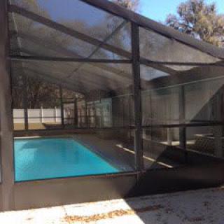A backyard pool with a screened enclosure.