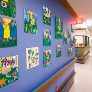 Colorful children's artwork brightening the hallway of a hospital.